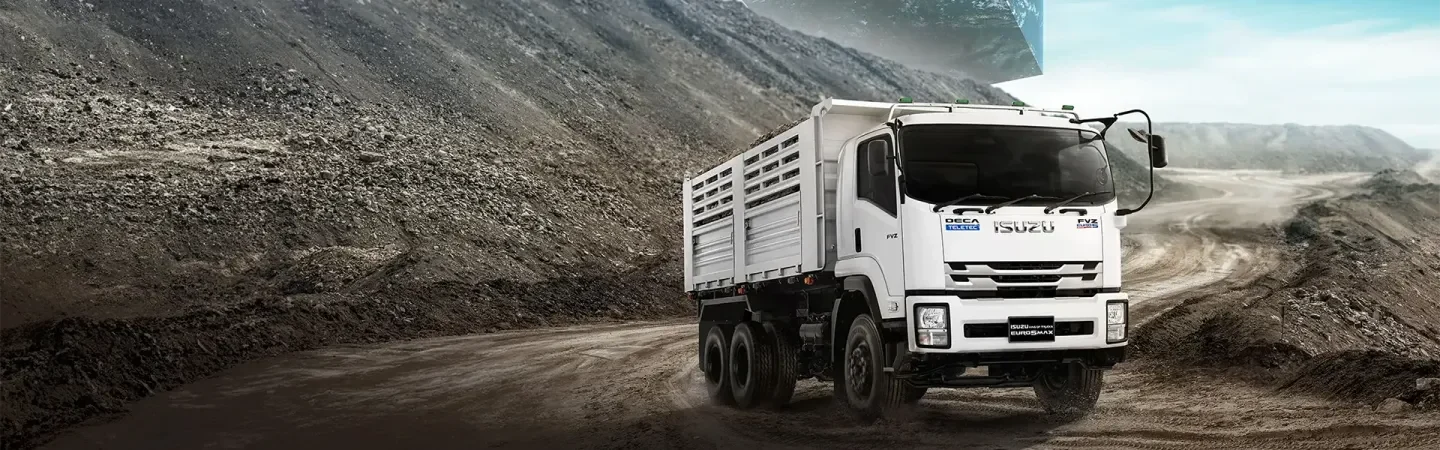 Isuzu FVZ สีขาวพร้อมตัวถังดัมพ์คอกในพื้นที่เหมืองและทางดิน